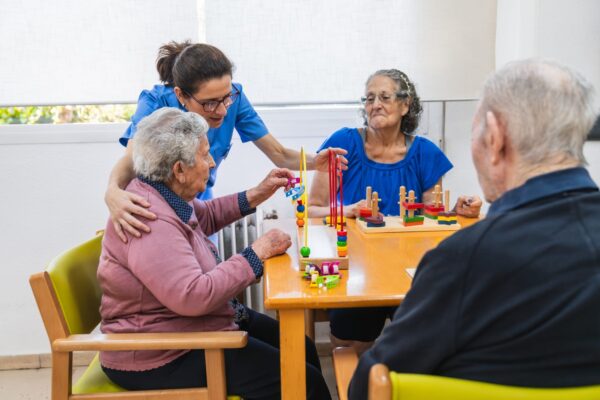 Caring nurse assisting seniors in nursing home