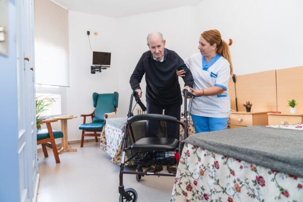 Elderly man receiving assistance in nursing home